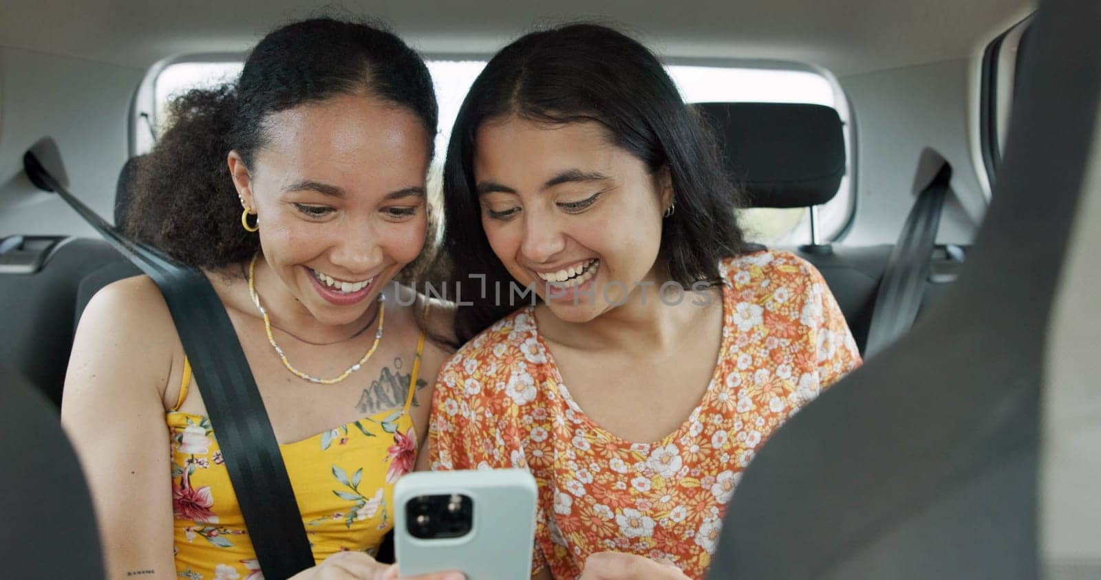 Woman, friends and phone on road trip with laugh, meme or smile with funny video, adventure or car. Girl, together and reading with blog, journey or holiday with comic video on web in transportation.