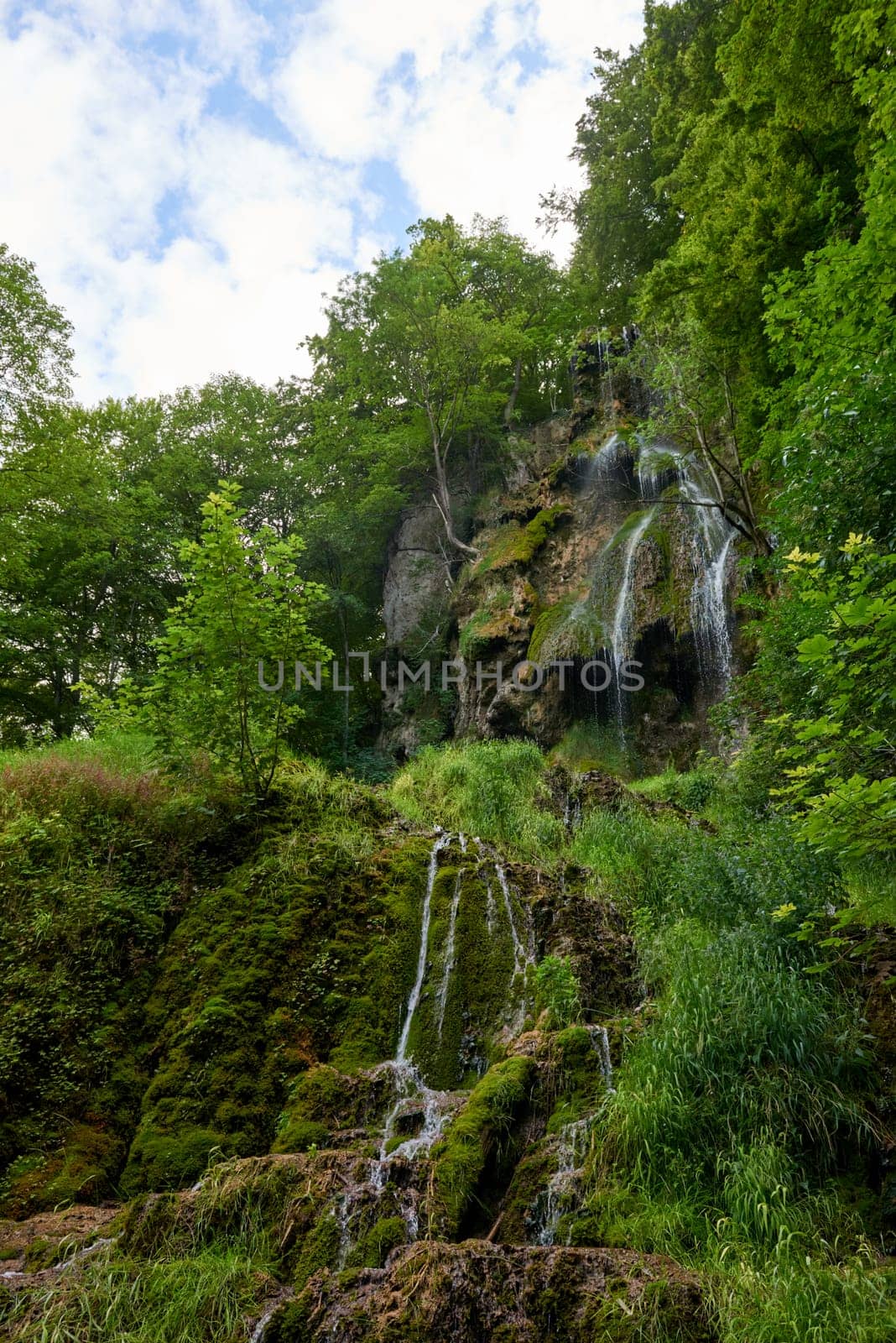 Majestic Cascade: Uracher Wasserfall Amidst Verdant Forest Landscape.