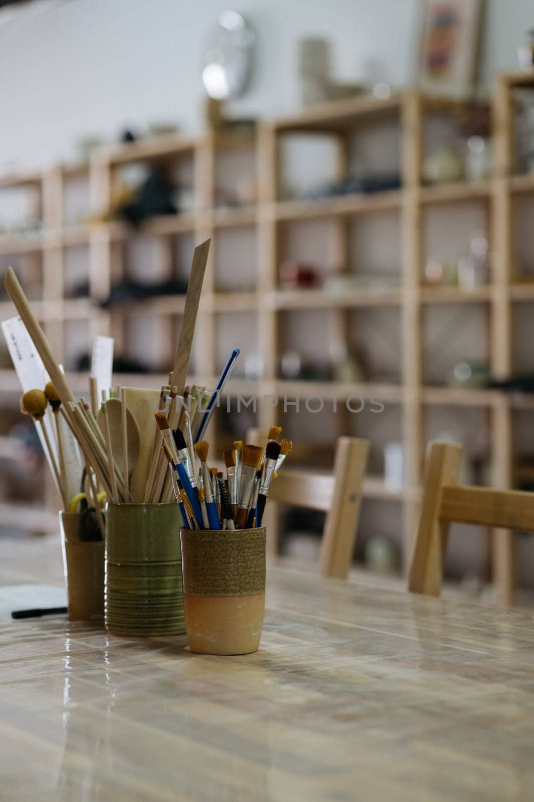 Artistic Pottery Studio Interior with Ceramic Tools and Brushes on a Work Table by apavlin
