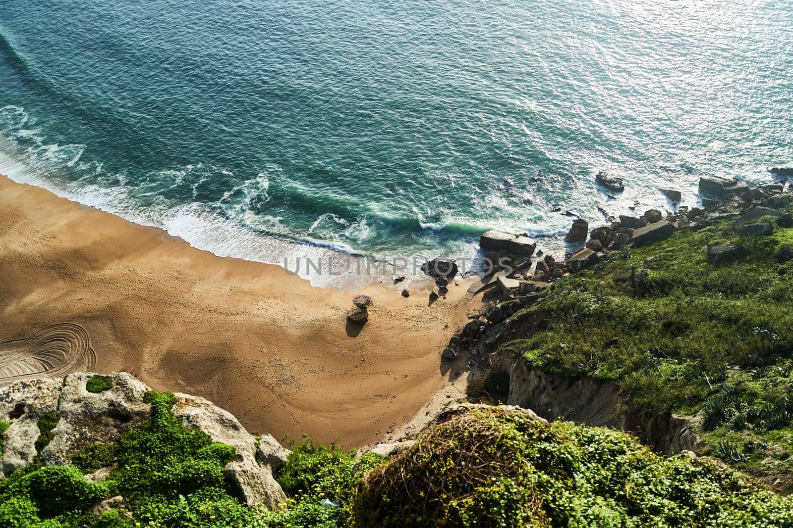 Coastal landscape from cliff, with ocean, beach, and lush greenery. Nazare by driver-s