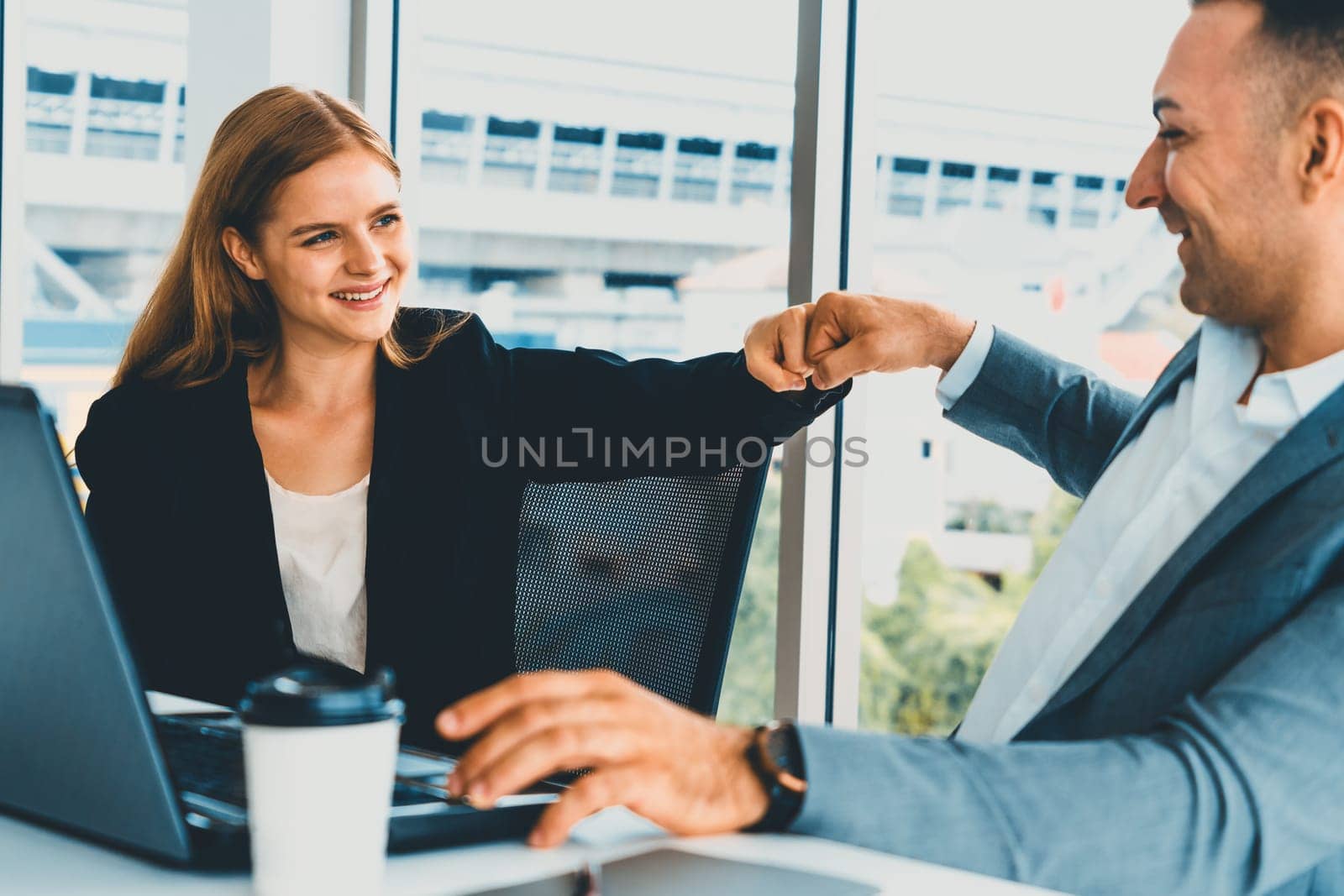 Success business partner - Businesswoman and businessman celebrating together in modern workplace office. People corporate teamwork concept. uds