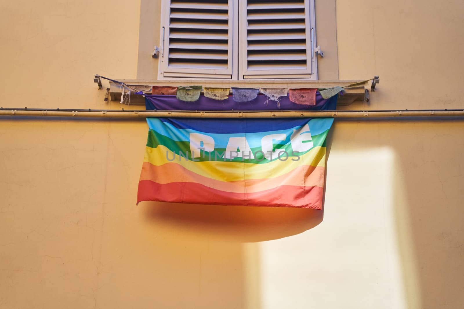 A rainbow flag with the word peace painted in blue, displayed as a creative arts fixture in a rectangular wood frame in a visual arts room