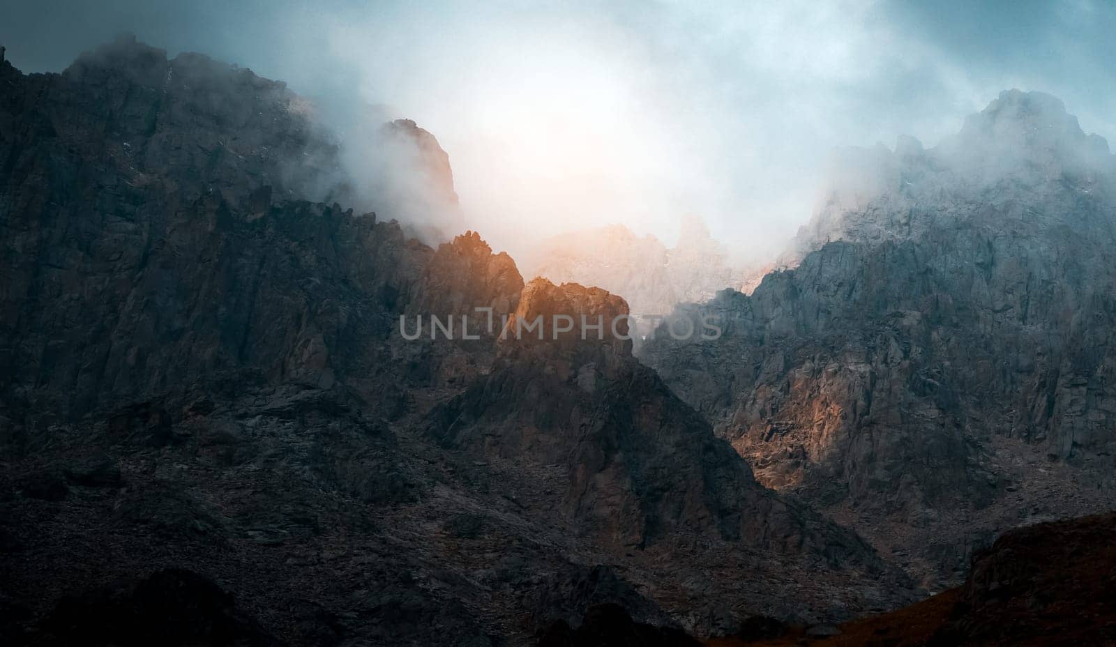 Thunder warning in the mountains, picturesque majestic rocky mountains scenery with an impending storm and the last light of the sun at sunset, wild nature without people.