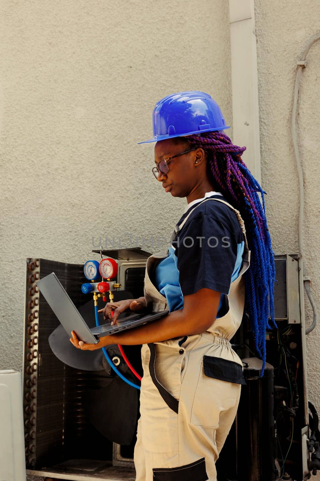 African american meticulous expert looking online for new air filters to replace outdoor air conditioner malfuntioning internal part during customer comissioned maintenance