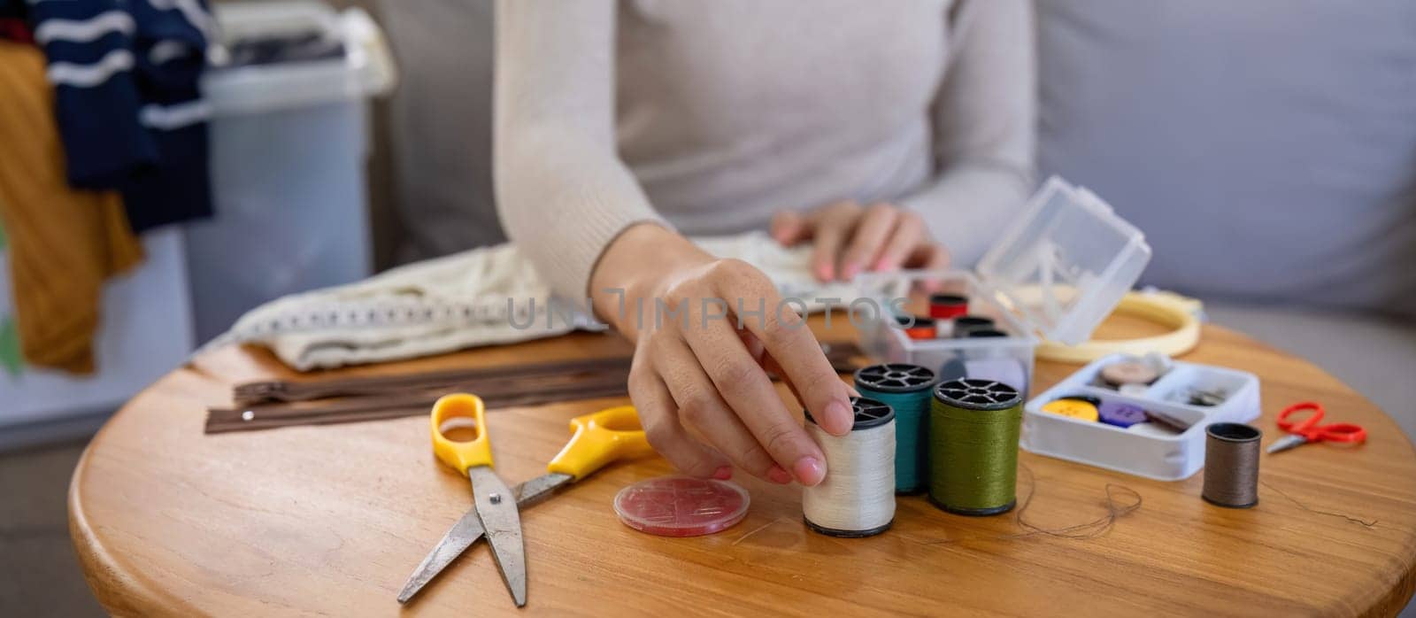 beautiful young woman sewing Repair damaged clothes so that it can be reused. In order to reduce the creation of waste and reduce environmental pollution..