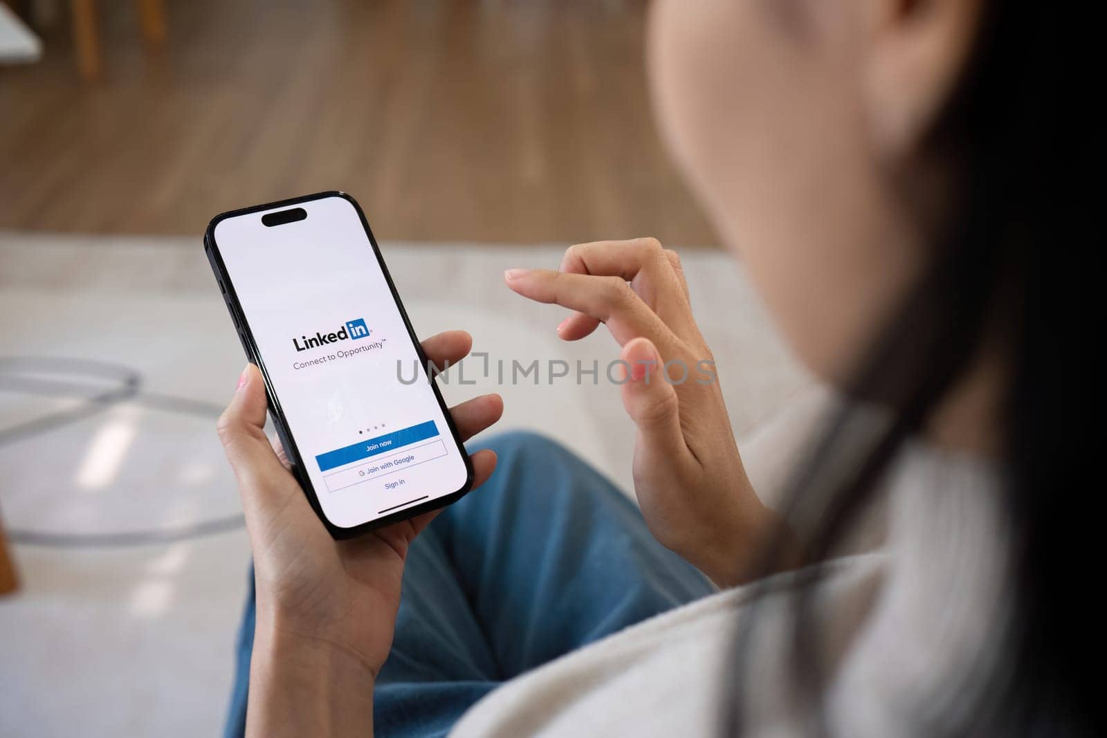 CHIANG MAI, THAILAND, FEB 27,2024 : A women holds Apple iPhone 14 Pro Max with LinkedIn application on the screen.LinkedIn is a photo-sharing app for smartphones. by wichayada