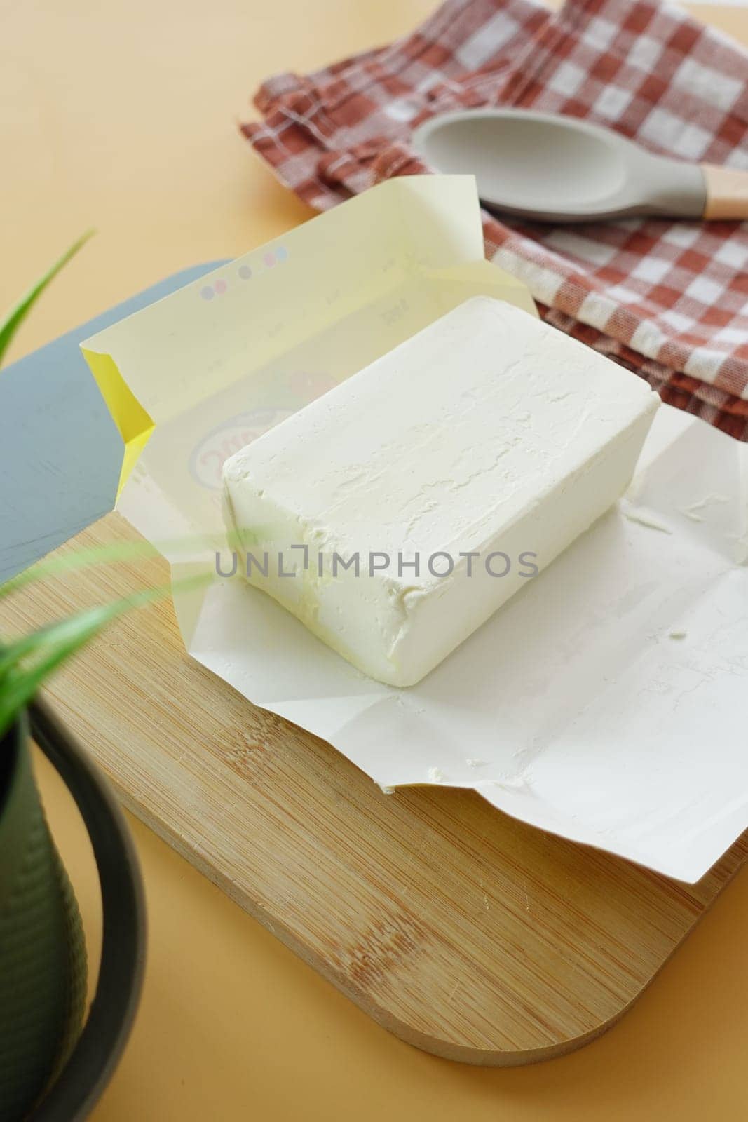 slice of a butter on a paper on table by towfiq007