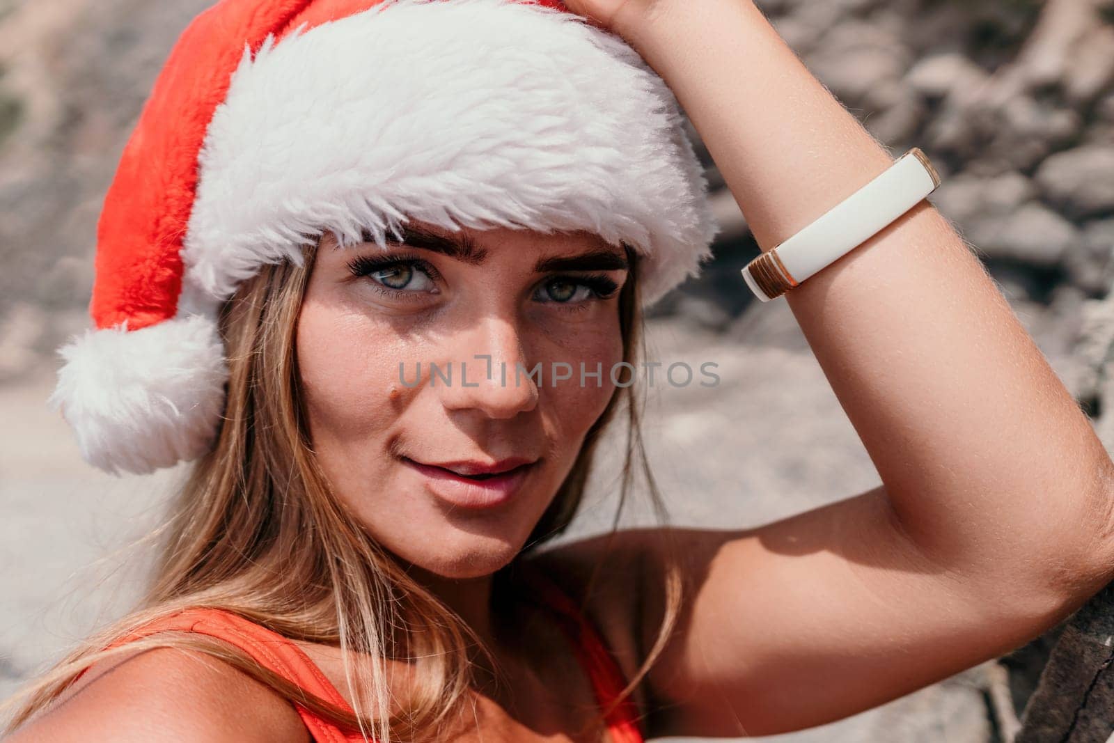 Woman travel sea. Young Happy woman in a long red dress posing on a beach near the sea on background of volcanic rocks, like in Iceland, sharing travel adventure journey