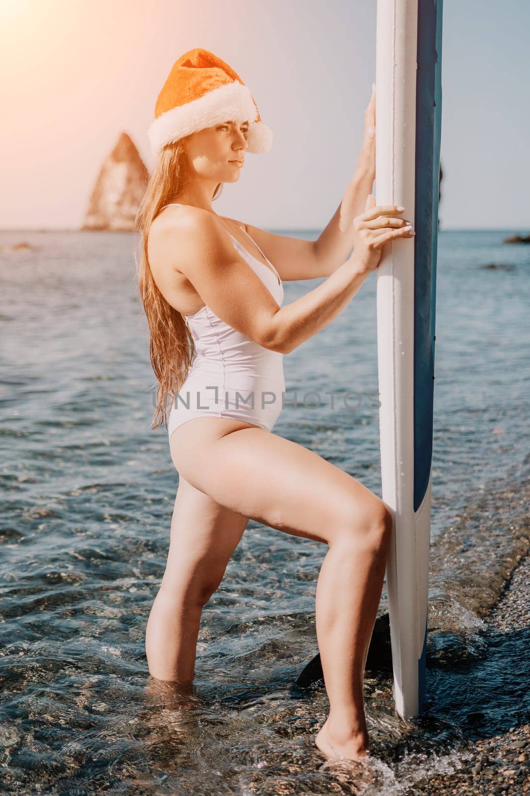 Close up shot of happy young caucasian woman looking at camera and smiling. Cute woman portrait in bikini posing on a volcanic rock high above the sea