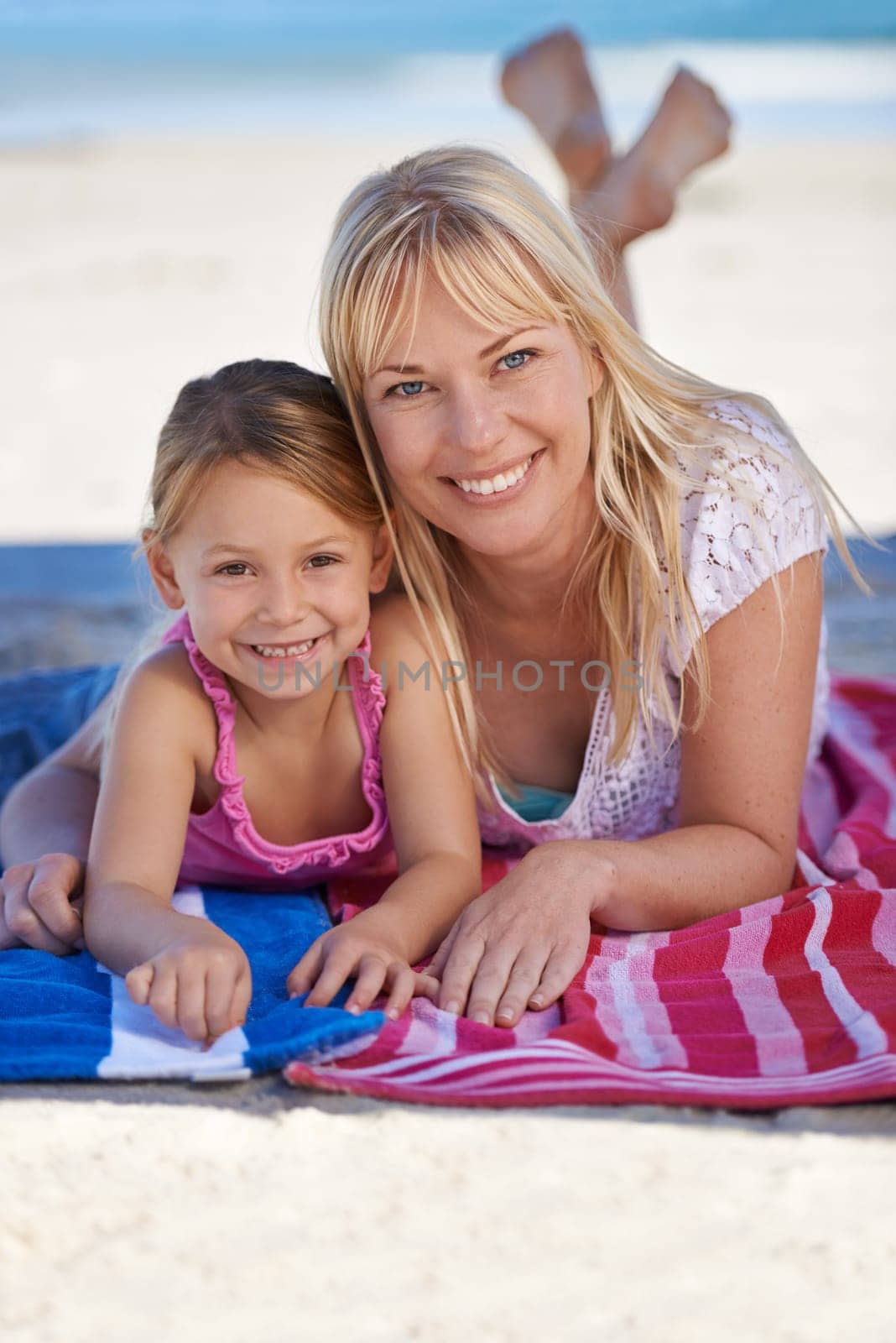 Portrait, mother and happy kid at beach to relax on holiday, summer or vacation on blanket. Face, mom and smile of girl at ocean for adventure, travel or family bonding together outdoor in nature.