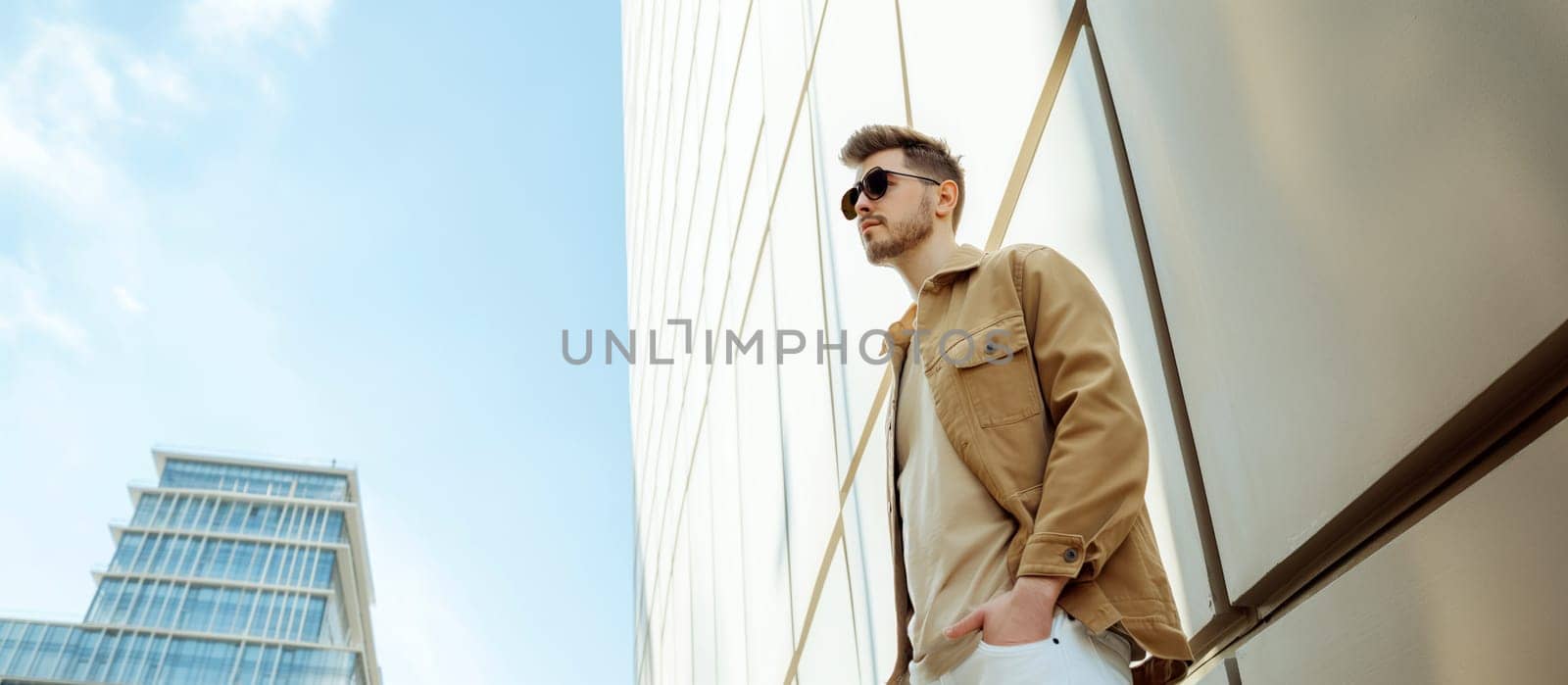 Stylish Man in Sunglasses Walking in Urban Environment on Sunny Day by chrisroll