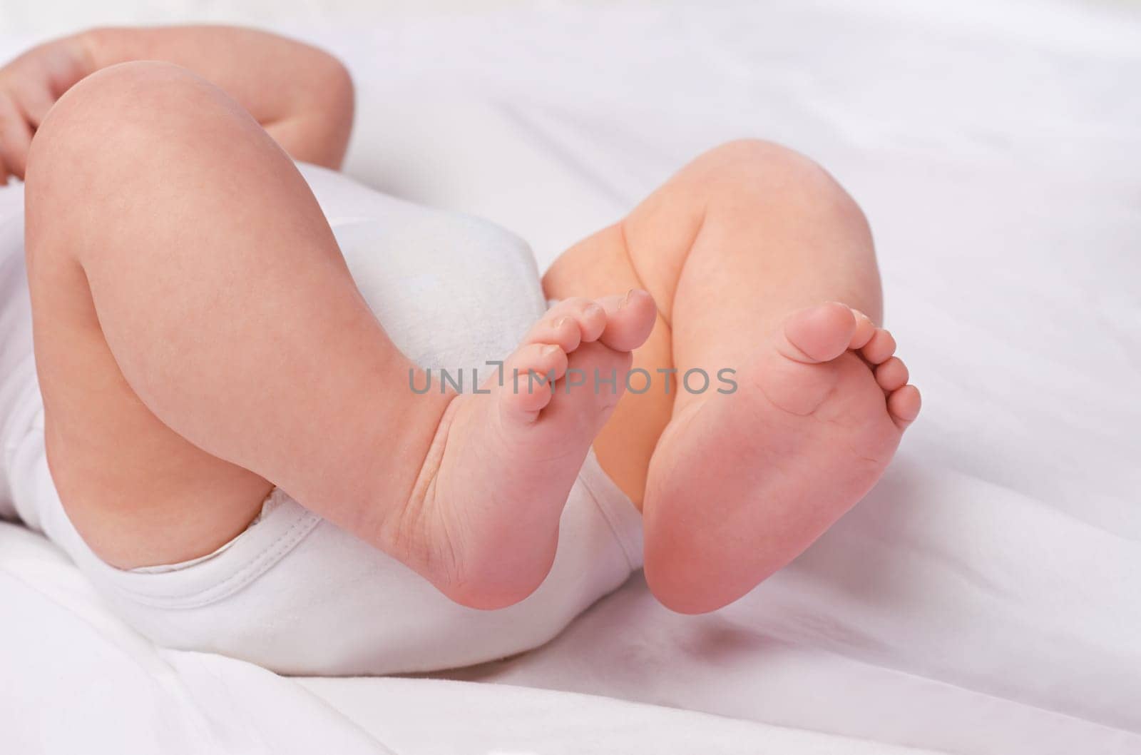Closeup, newborn baby or feet for relax, bed and nap for healthy childhood, care and development. Bare foot, leg and toes of young child for calm, rest and sleeping in peaceful nursery for dreaming by YuriArcurs