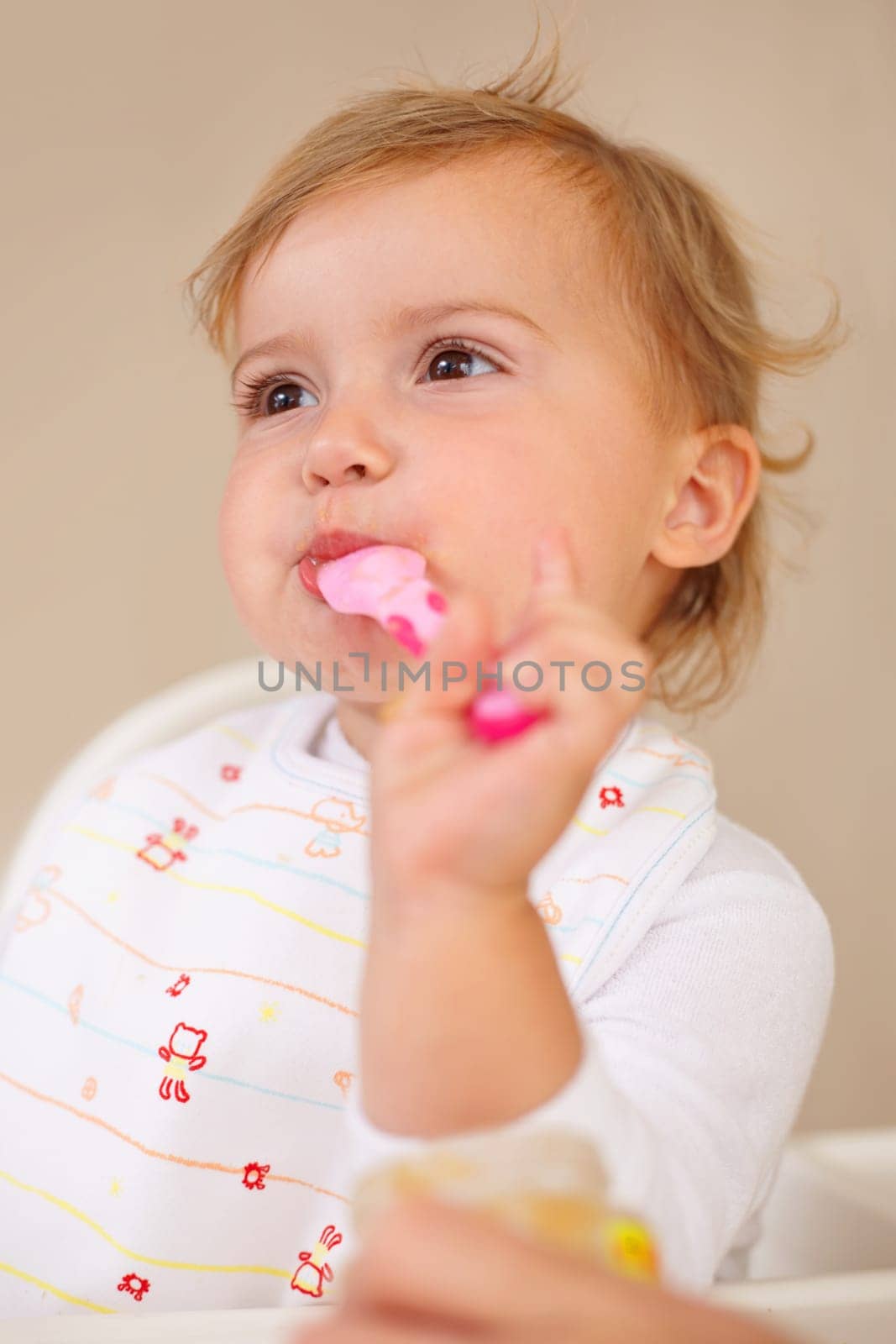 Baby girl, spoon and eating for nutrition, food and development with enjoyment at house, living room and home. Female child, infant and kid happy for feeding, breakfast and snack for growth.