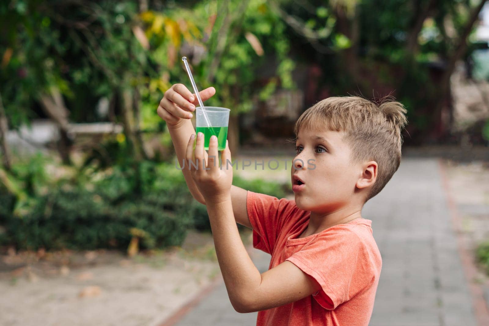 Scientific discovery family education at home. Boy surprise chemical experiments outside nature.