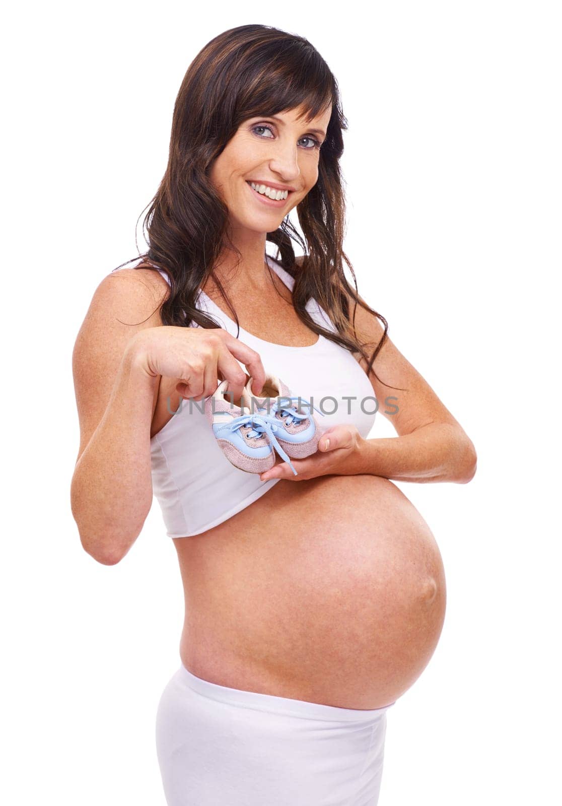 Woman, pregnant and studio with portrait, smile and baby shoes for maternity and confidence. Mother, proud and confident with pregnancy, child and stomach for positive parenting and motherhood.