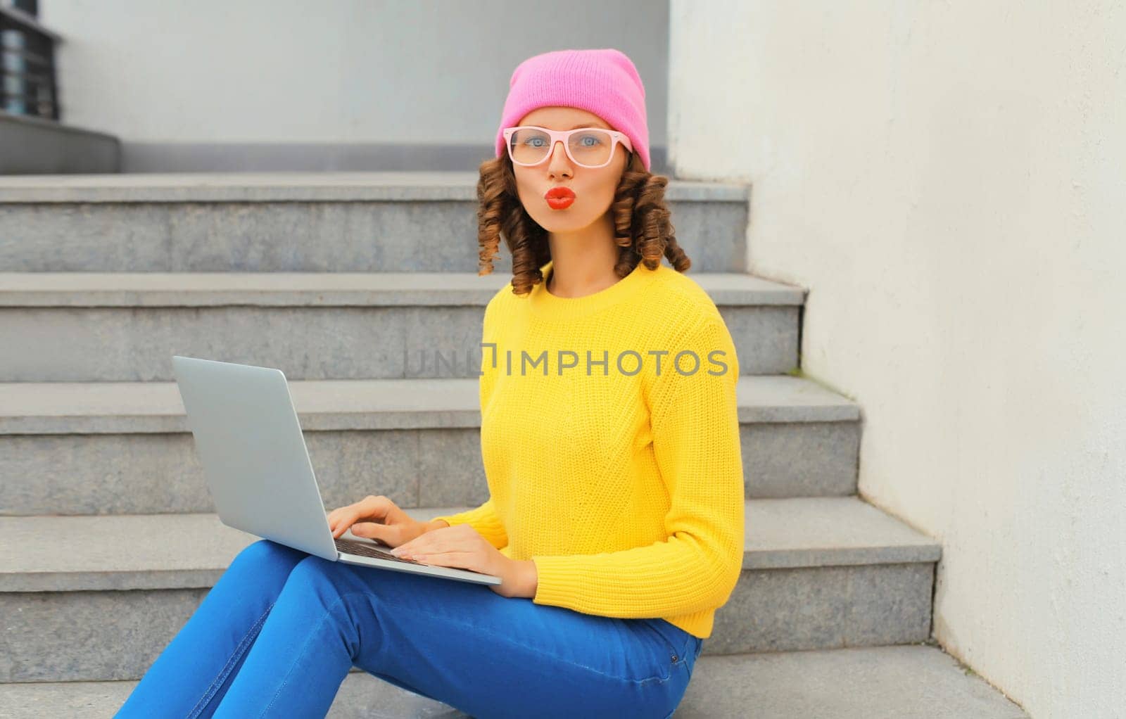 Portrait of modern cool young woman with laptop in the city