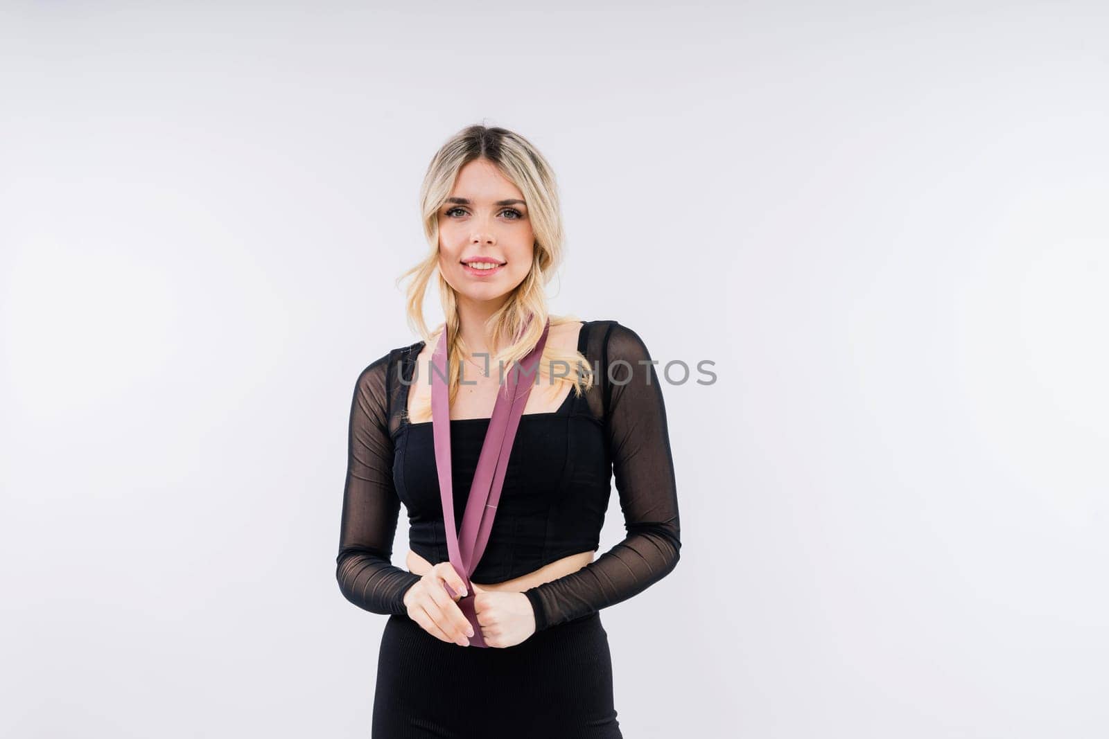 Young woman workout with resistance band on white background. Strength and motivation. by Zelenin