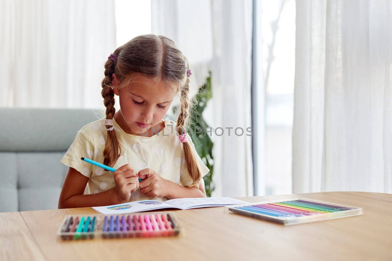 Girl with braids chooses bright felt-tip pen to draw picture by Demkat