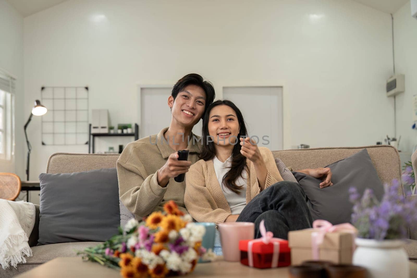 Asian couple lifestyle, man and woman watch TV movie at home, family lifestyle relax and recreation concept. fall in love. Valentine concept by nateemee