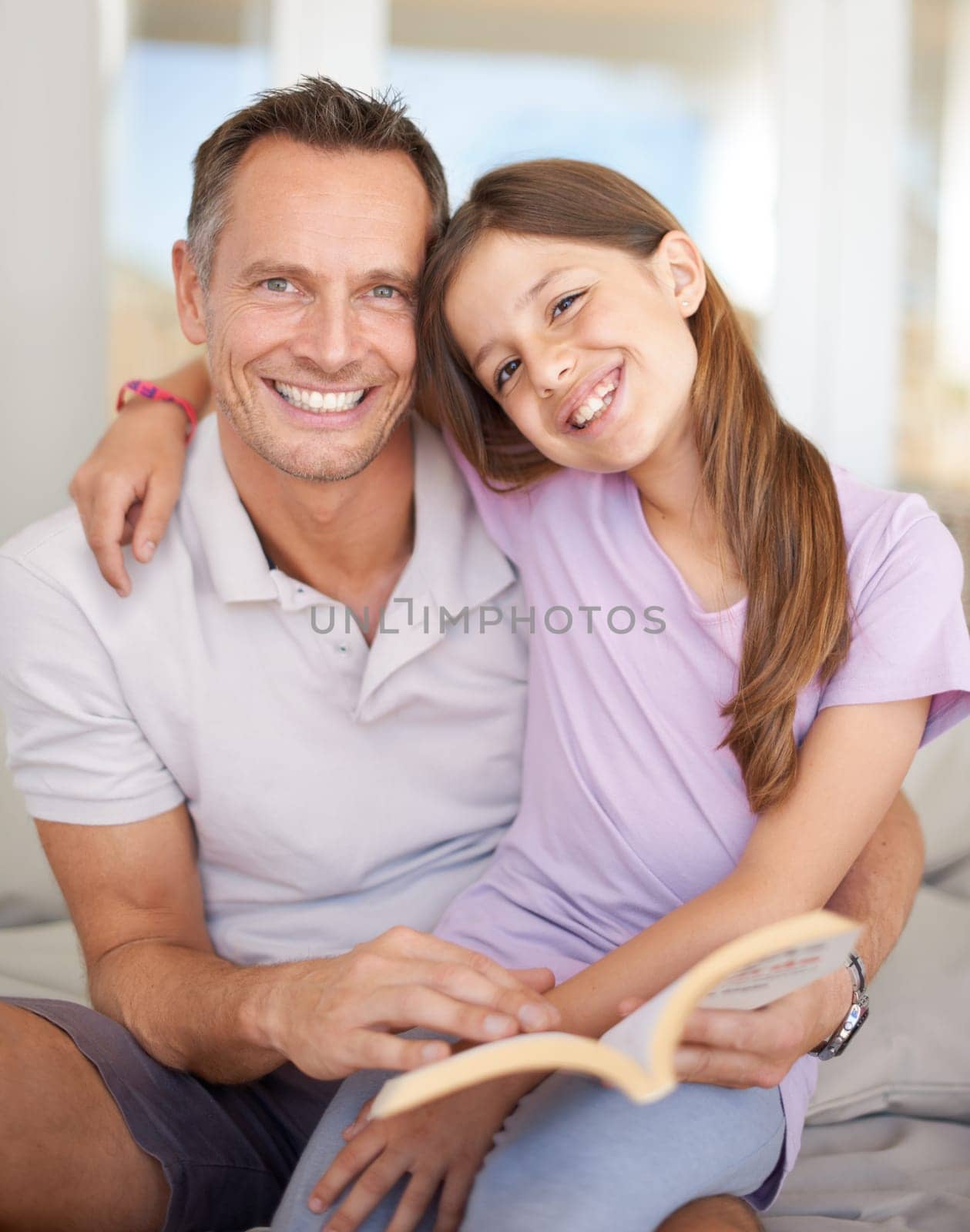 Father, girl and book on sofa for portrait with hug, care and connection in family home with reading. Dad, child and happy together on couch with teaching, education and embrace for bonding in house.