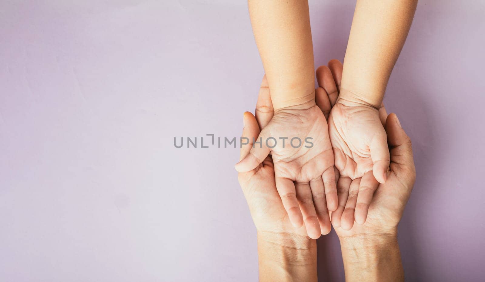 Celebrating family day, Parents and kid holding empty hands together on a color background. Space for text. by Sorapop