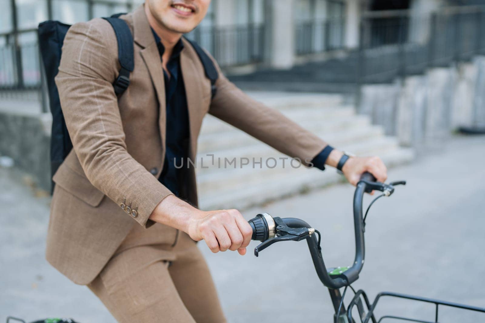 Young businessman in suit in city bike to work eco friendly alternative vehicle green energy.