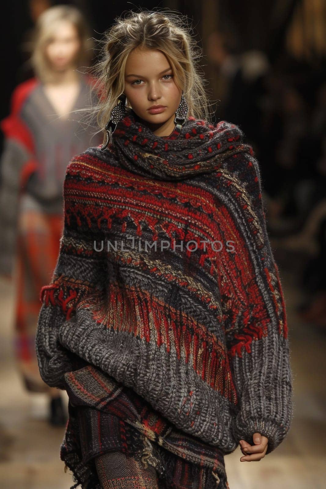 A model walks down the runway in a sweater and skirt