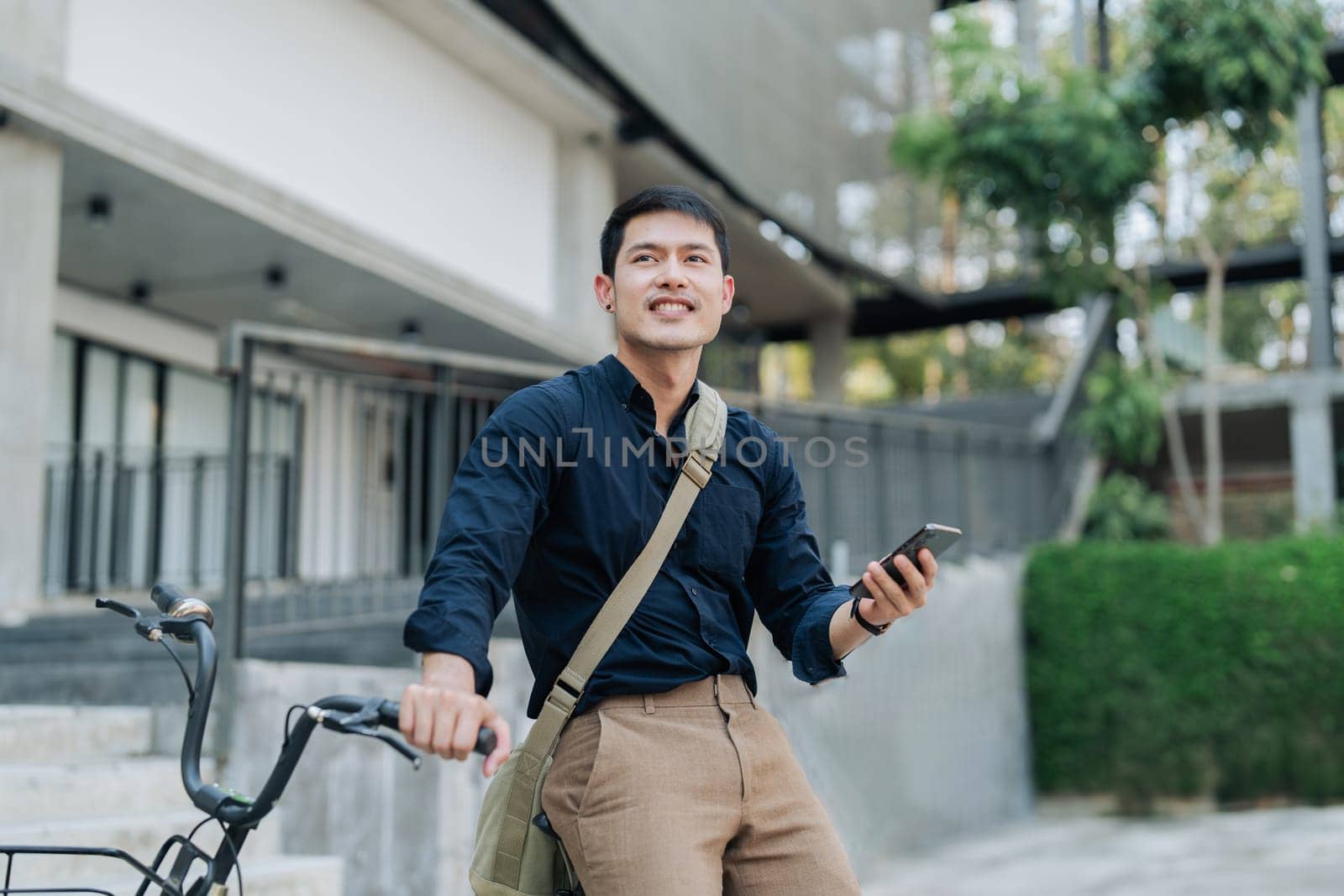asian young businessman use smart phone while commuting in city. Eco friendly by itchaznong