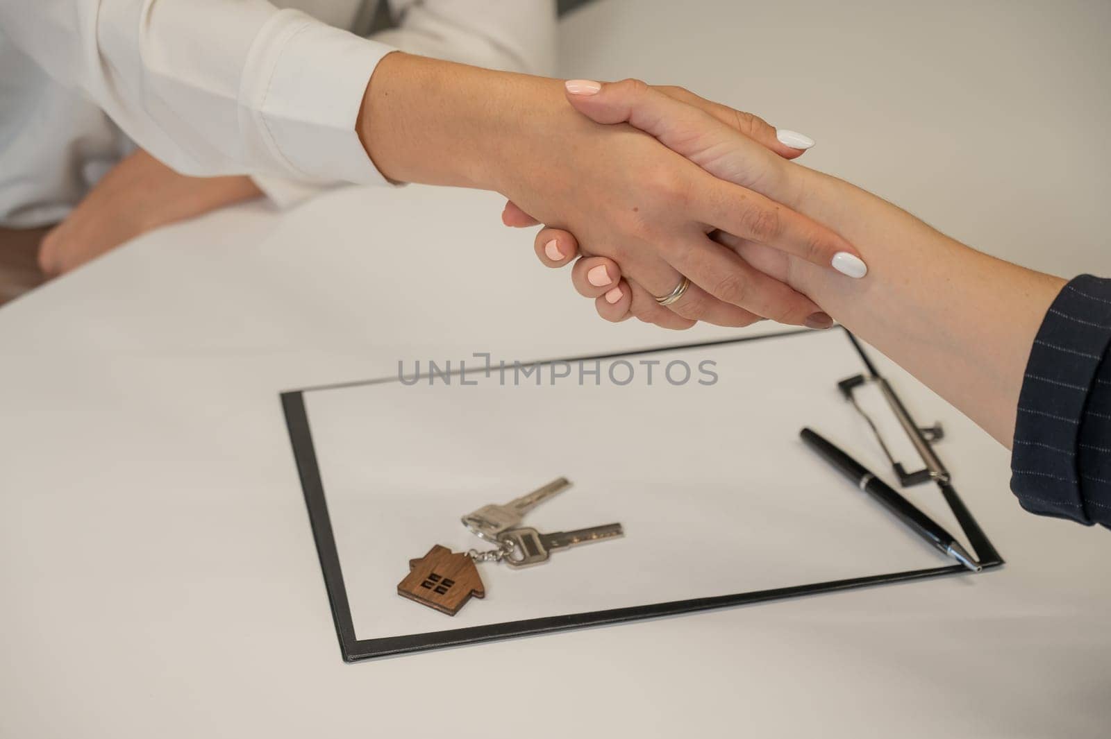 Real estate purchase transaction. Realtor and buyer shaking hands. by mrwed54