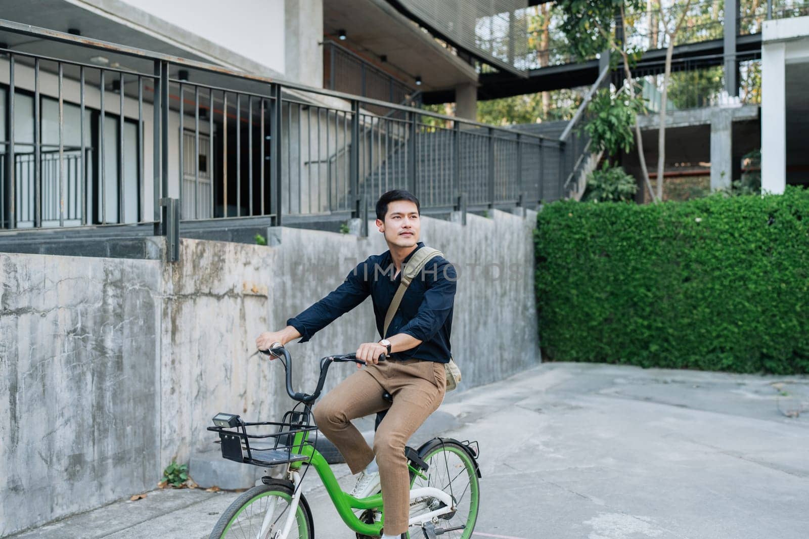 Young businessman in suit in city bike to work eco friendly alternative vehicle green energy by itchaznong