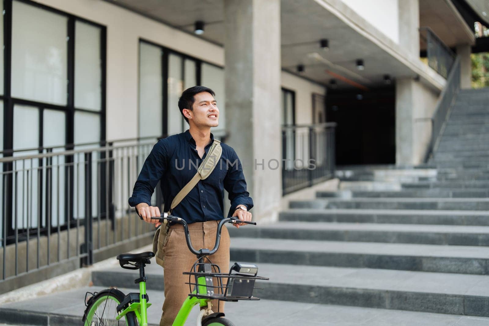 Young businessman in suit in city bike to work eco friendly alternative vehicle green energy.