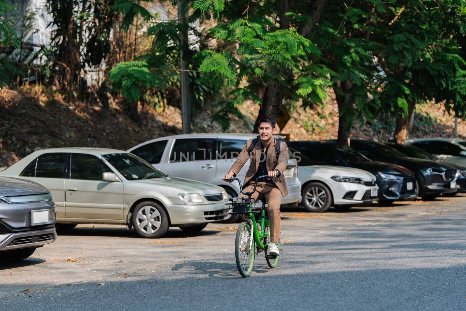 Elegant entrepreneur in smart casual cycling on bicycle track in warm sunny day area of city.