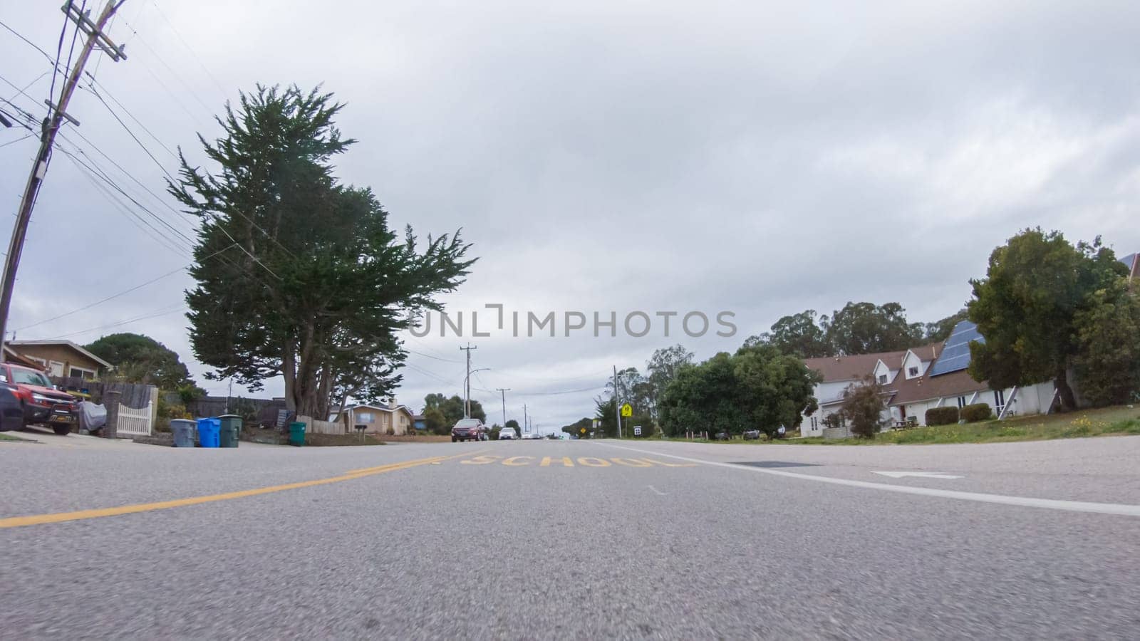Santa Maria, California, USA-December 6, 2022-Vehicle navigates the streets of Morro Bay, California, during a cloudy winter day. The atmosphere is moody and serene as the overcast sky casts a soft light on the charming buildings and quiet streets of this coastal town.