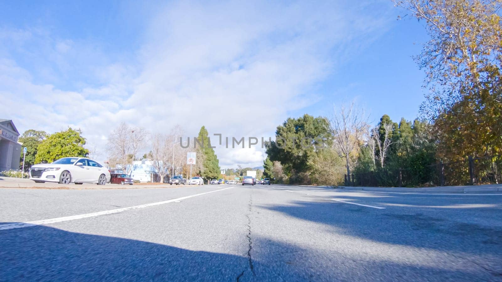 Santa Maria, California, USA-December 6, 2022-On a crisp winter day, a car cruises along the iconic Highway 1 near San Luis Obispo, California. The surrounding landscape is brownish and subdued, with rolling hills and patches of coastal vegetation flanking the winding road.