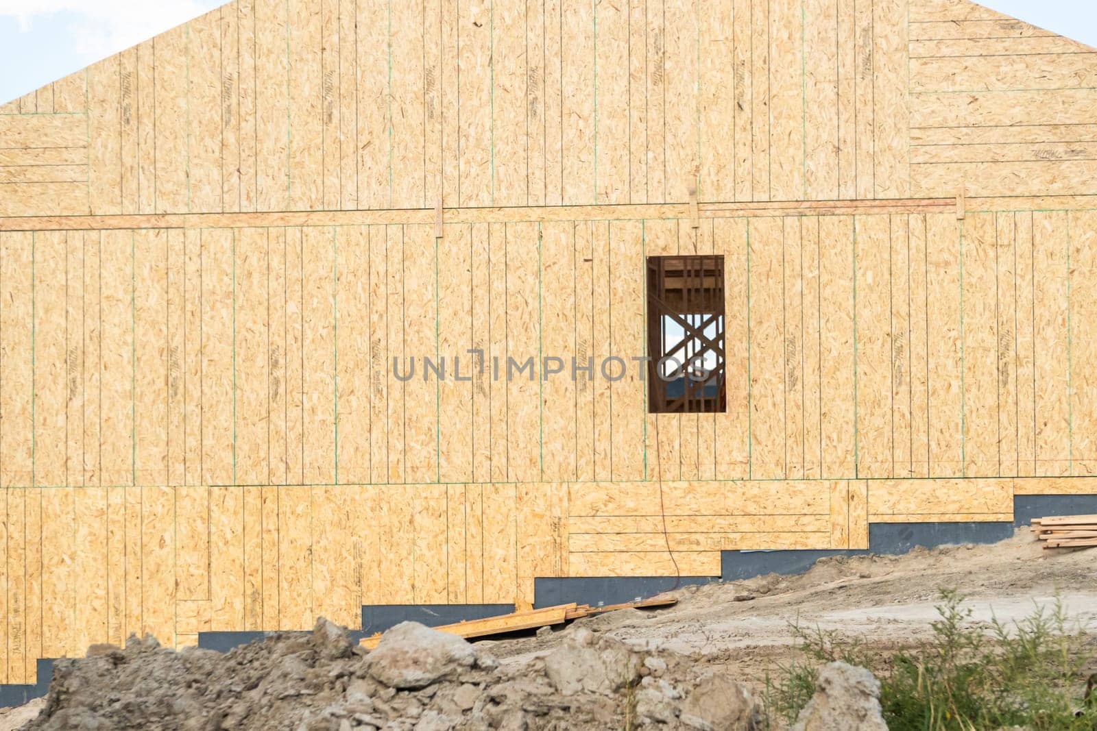 An ongoing construction site in the suburbs, featuring the framing stage of a single-family house.