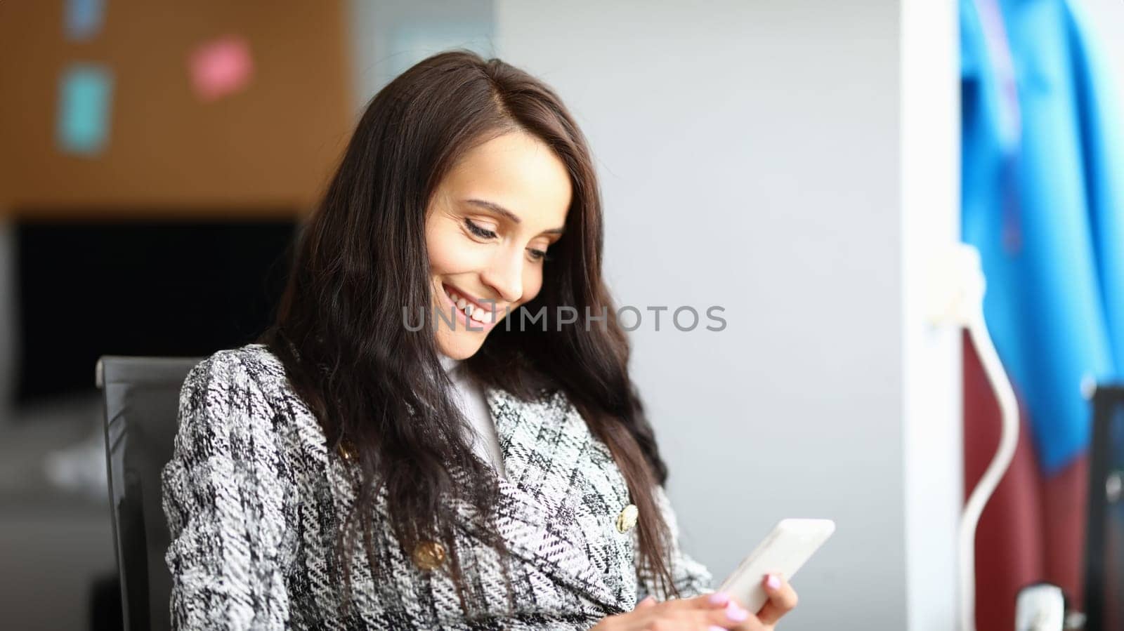 Portrait of smiling brunette woman using smartphone. Happy female get nice message. Talk to good friend. Copy space in right side. Communication and technology concept