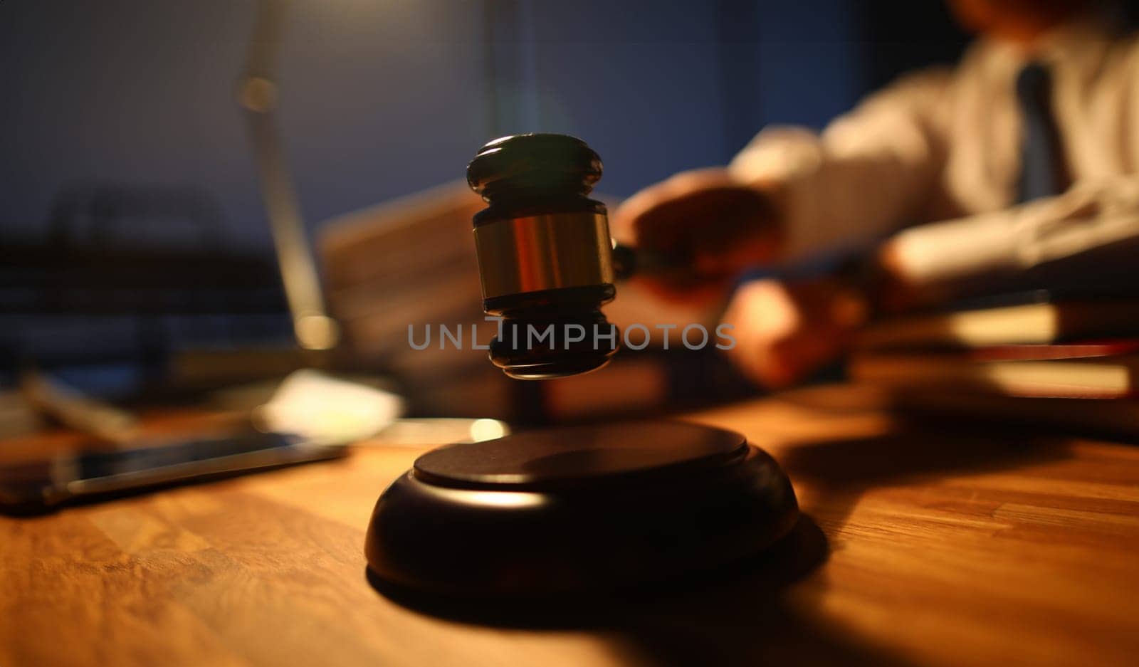 Focus on judge utility on wooden table used to maintain order and pronounce a verdict in courtroom in front of many people. Rule of law and strict court concept