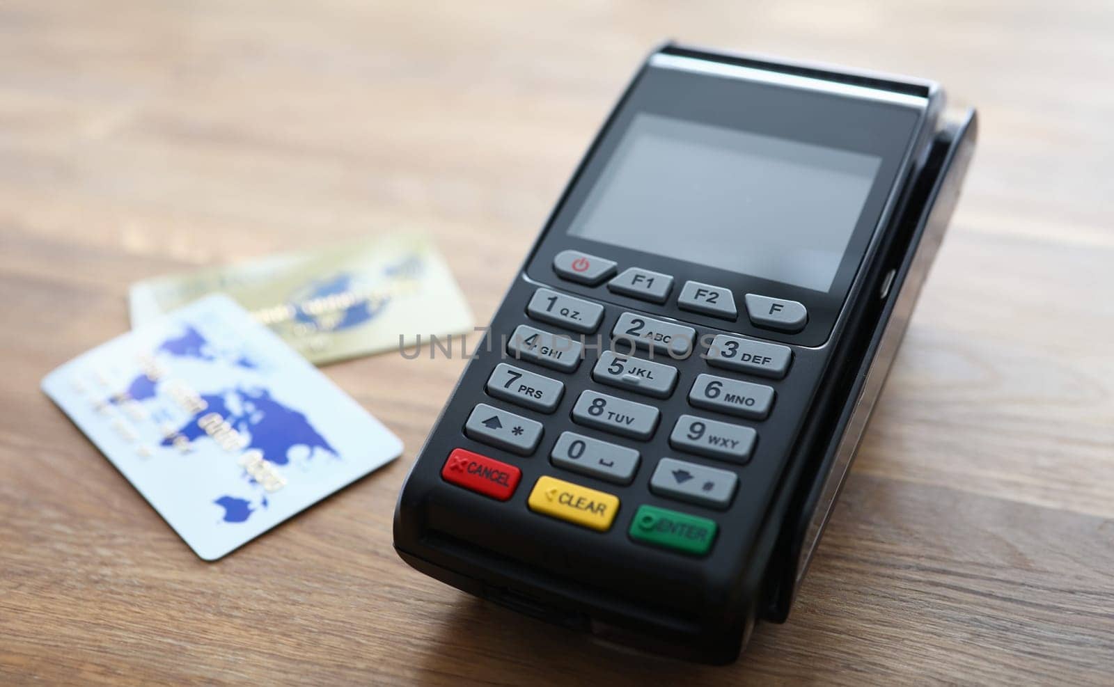 Close-up view of payment terminal and credit cards on wooden table. Modern card reader for online paying. Buy and sell products or service. Technology concept