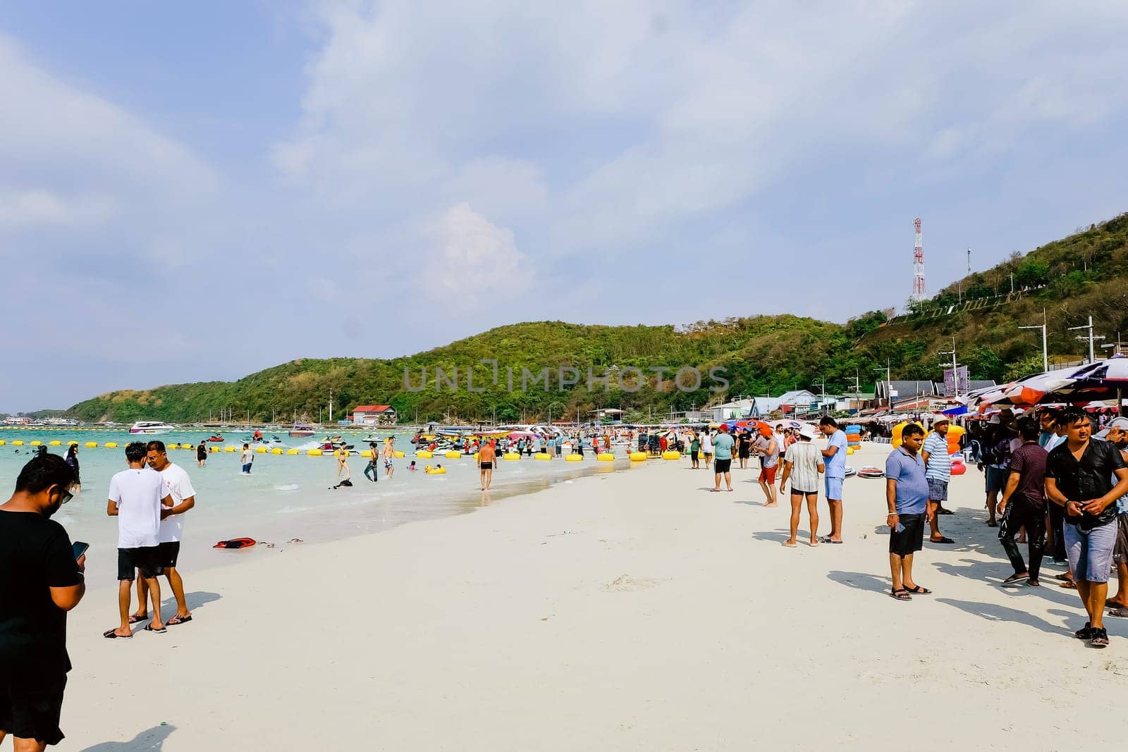 PATTAYA, THAILAND -MARCH 25 2024: Unidentified people on the beach in Nual Beach at Koh Lan, Pattaya, Chonburi Province,Thailand