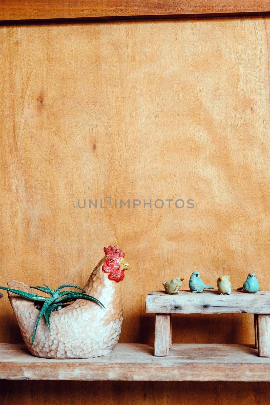 Still life image of Wooden bench and small birds with plant pot on wooden background.