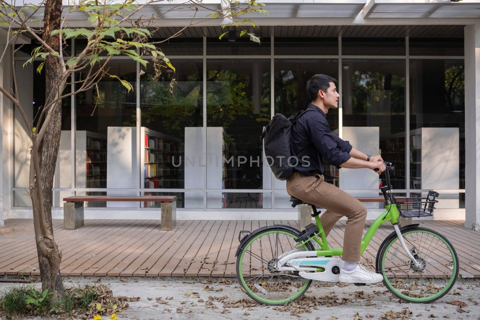 Young Asian businessman Go to work by cycling to reduce air pollution and stay healthy. by wichayada