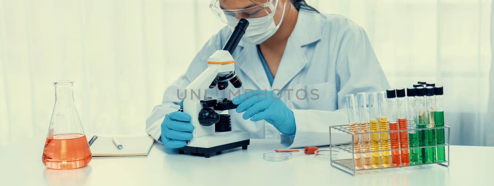 Laboratory researcher develop new medicine or cure using microscope. Technological advance of healthcare with scientific expertise with laboratory microbiology equipment. Panorama Rigid