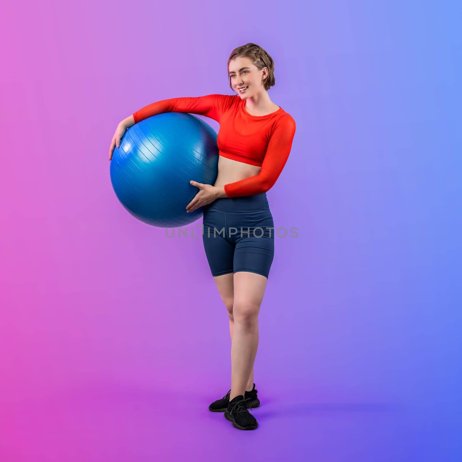 Full body length gaiety shot athletic and sporty young woman with fitness exercising ball in standing posture on isolated background. Healthy active and body care lifestyle.