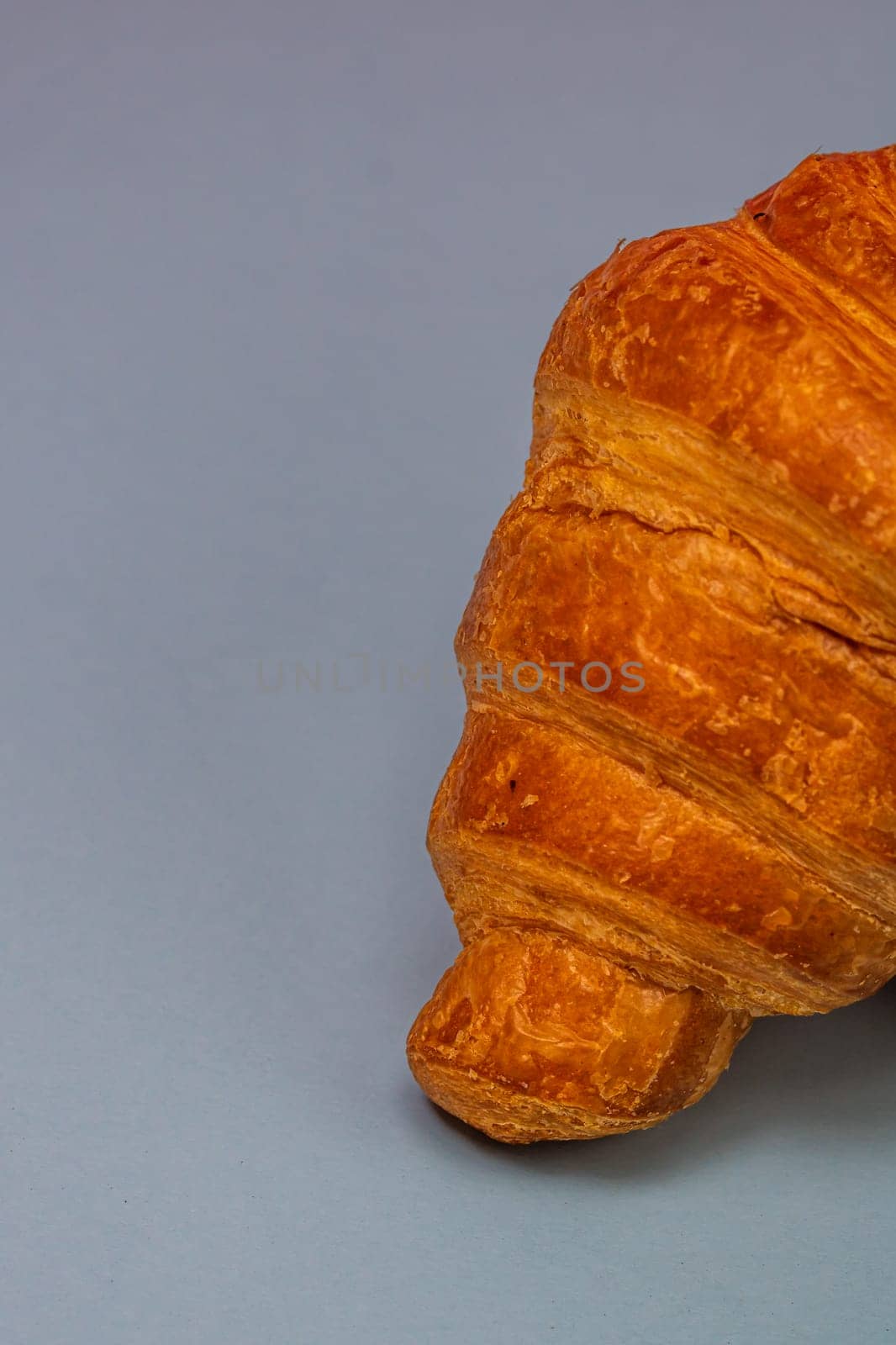 Detail of fresh croissant isolated, french breakfast concept. by vladispas