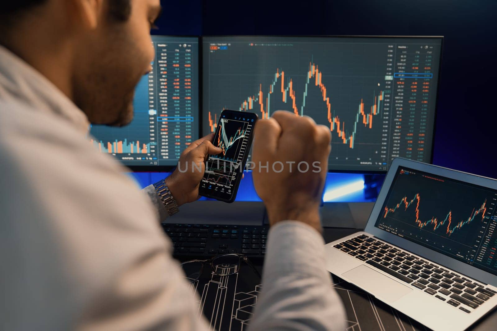 Smart trader businessman concentrating on dynamic stock exchange investment on pc and laptop showing on screen with high profit in searching market at neon light office in dark room night. Surmise.