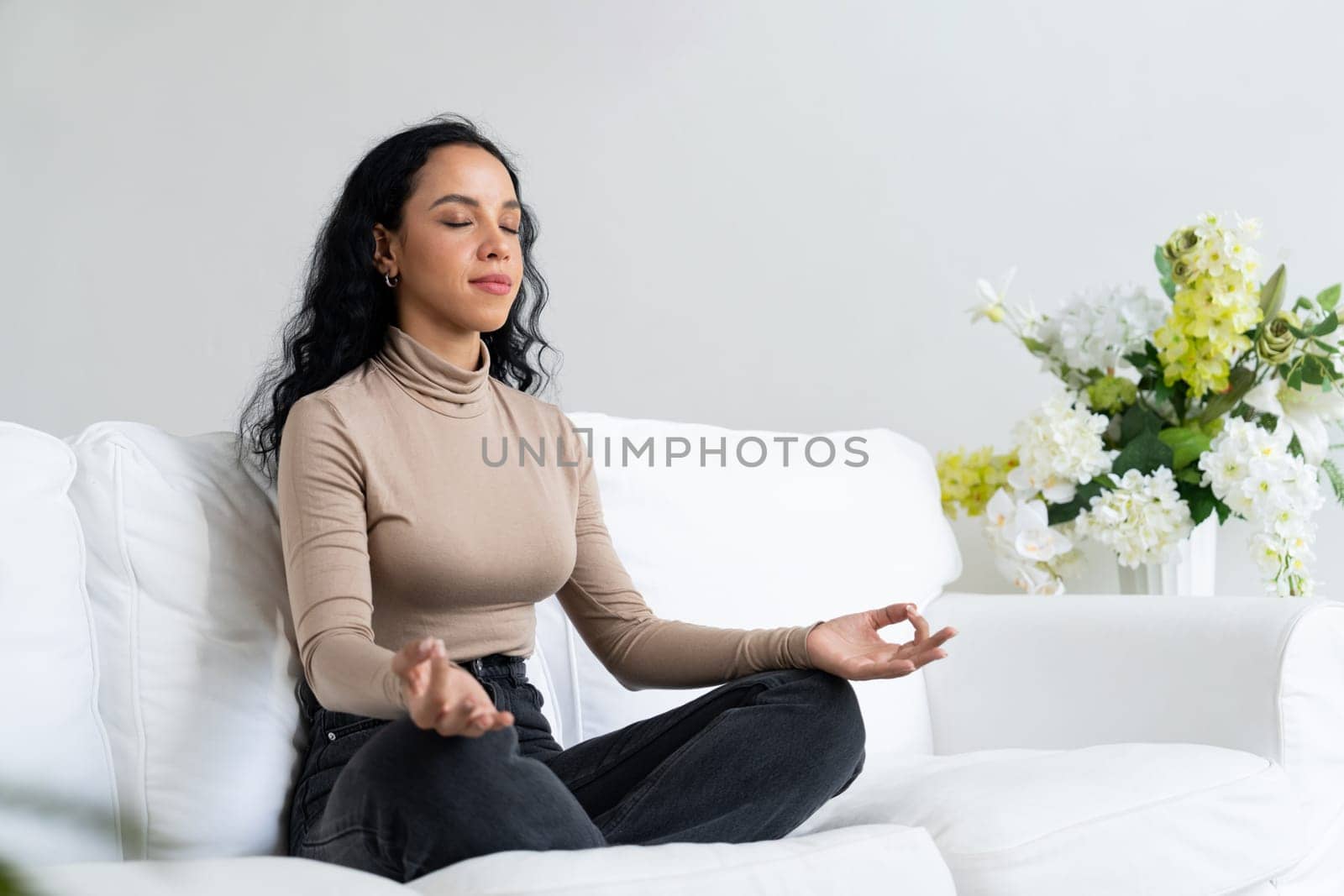 Young African American woman practice crucial mindful meditation at home living room for improving mental health strength and peaceful beautiful living