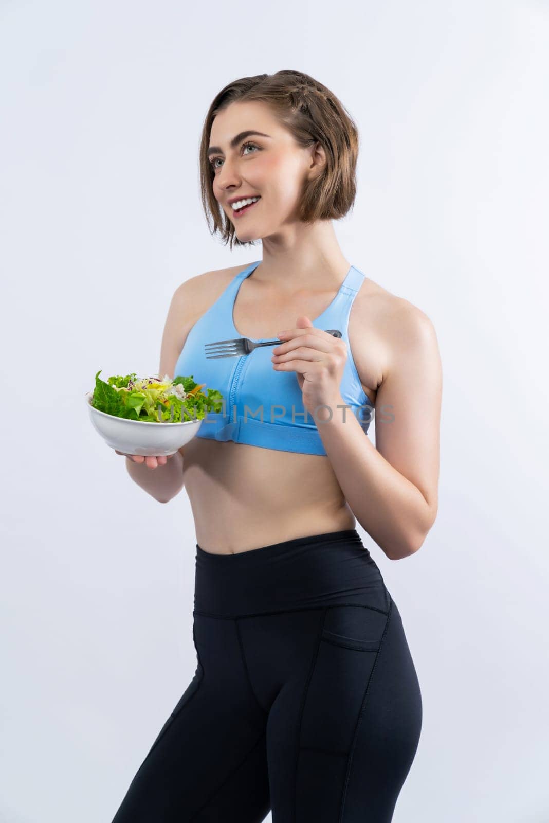 Full body length gaiety shot athletic and sporty young woman with healthy vegan food in standing posture on isolated background. Healthy active and body care by vegetarian lifestyle.