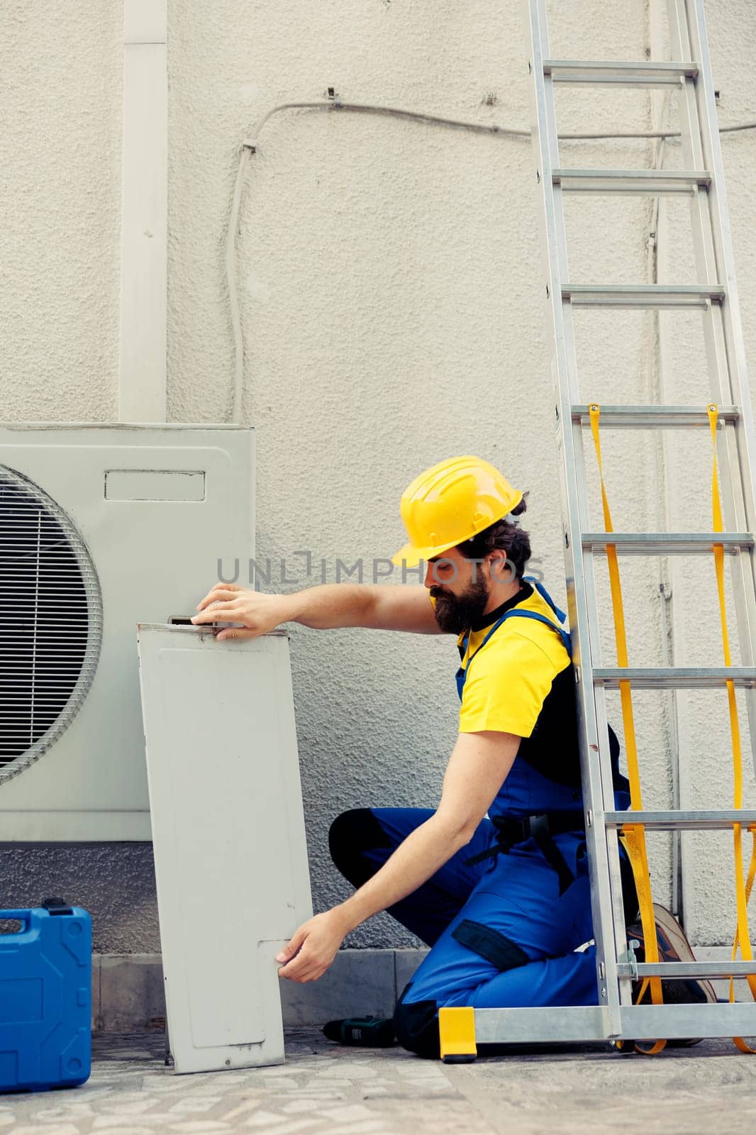 Serviceman working on air conditioner by DCStudio