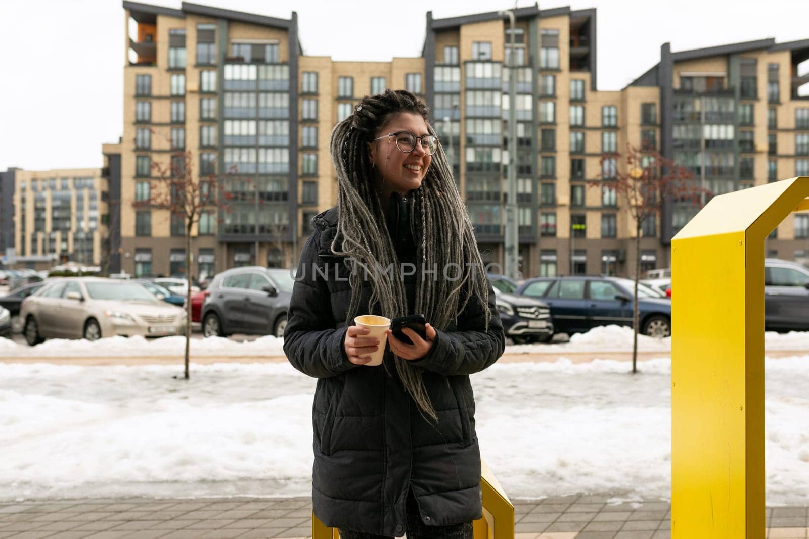 Cute young woman with dreadlocks hairstyle looks informal and unusual.