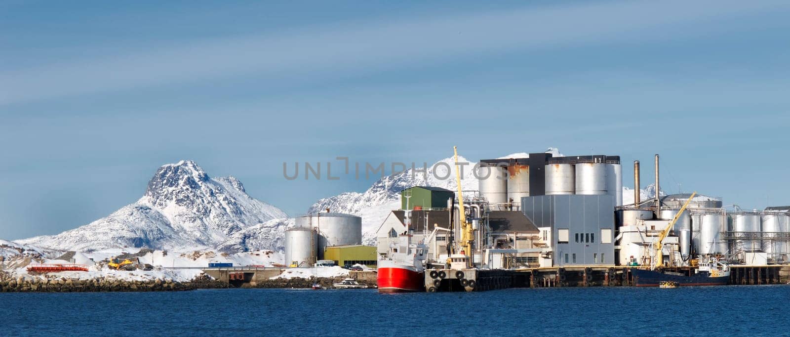 Fishing, plant and industrial tank on water for processing, production and feed mill for fish industry in Norway. Manufacturing, containers and warehouse for agriculture and sea factory with blue sky.